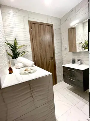 a bathroom with a sink and a mirror and a counter at Emerald Luxury Apartments - ATH Airport in Spáta