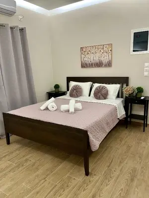 a bedroom with a bed with two stuffed animals on it at Emerald Luxury Apartments - ATH Airport in Spáta