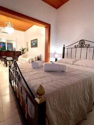 a bedroom with a large bed and a piano at Emerald Luxury Apartments - ATH Airport in Spáta