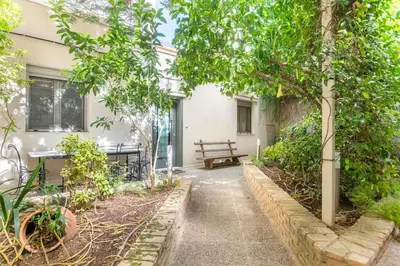 a garden with a bench and trees in front of a building at Pop Art Home - Experience Local Vibes in Athens