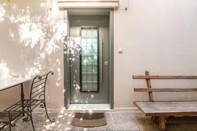 a door on a building with a bench and a table at Pop Art Home - Experience Local Vibes in Athens