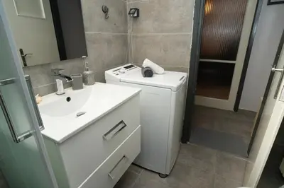 a bathroom with a sink and a washing machine at Angel Apartment in Athens