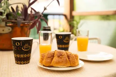 a table with a plate of bread and two glasses of orange juice at Angel Apartment in Athens