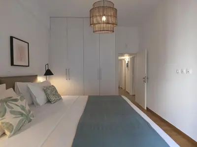 a large white bed in a bedroom with a light fixture at Aiginitou6 in Athens