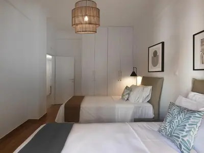 a hotel room with two beds and a chandelier at Aiginitou6 in Athens