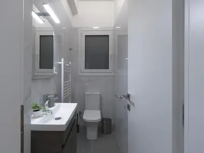 a white bathroom with a sink and a toilet at Aiginitou6 in Athens
