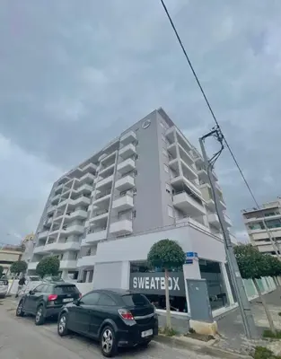 a large white building with cars parked in front of it at Cozy 2-bedroom Apartment in Piraeus (ERM_E9) in Piraeus