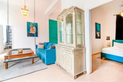 a living room with a blue couch and a grandfather clock at Neoclassical Loft in Monastiraki - Acropolis and metro in Athens