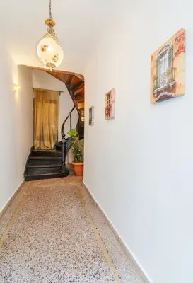 a hallway with a staircase with a chandelier and a room at Neoclassical Loft in Monastiraki - Acropolis and metro in Athens