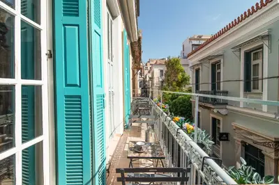 a balcony in a city with tables and chairs at Neoclassical Loft in Monastiraki - Acropolis and metro in Athens