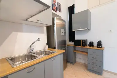 a kitchen with a sink and a refrigerator at Neoclassical Loft in Monastiraki - Acropolis and metro in Athens