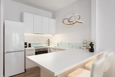 a white kitchen with white appliances and a white counter top at Acropolis Sherlock Residence in Athens