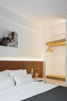 a bedroom with a white bed and a wooden wall at Acropolis Sherlock Residence in Athens
