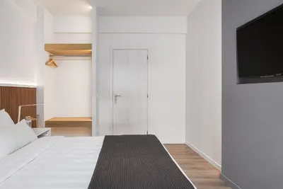 a bedroom with a bed and a flat screen tv at Acropolis Sherlock Residence in Athens