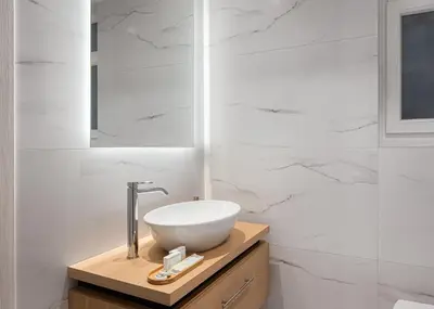 a bathroom with a white sink and a mirror at Acropolis Sherlock Residence in Athens
