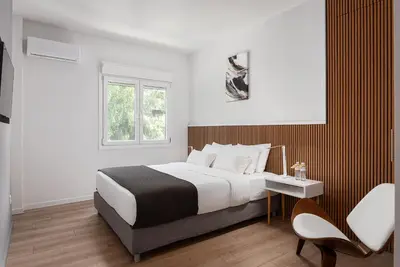 a bedroom with a bed and a table and chairs at Acropolis Sherlock Residence in Athens
