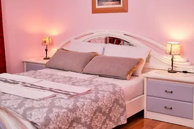 a bedroom with a white bed and two night stands at Marina's Luxurious Apartment in Athens, Centre in Athens