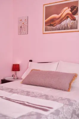 a bedroom with a white bed with a painting on the wall at Marina's Luxurious Apartment in Athens, Centre in Athens