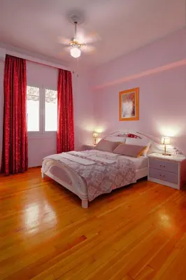 a bedroom with a large bed and red curtains at Marina's Luxurious Apartment in Athens, Centre in Athens