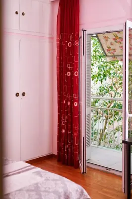 a bedroom with a red curtain and a window at Marina's Luxurious Apartment in Athens, Centre in Athens