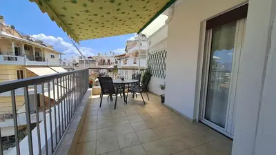 a balcony with a table and chairs on it at Tomis Sea View Apartment in Piraeus