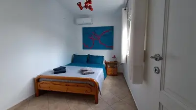 a bedroom with a bed with a blue painting on the wall at Tomis Sea View Apartment in Piraeus