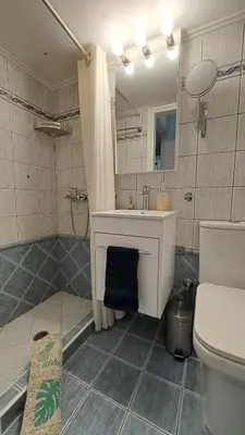 a bathroom with a sink and a toilet and a mirror at Tomis Sea View Apartment in Piraeus