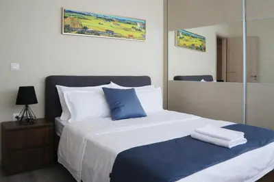 a bed with blue and white pillows and a mirror at Dafni City Apartment 3 in Athens