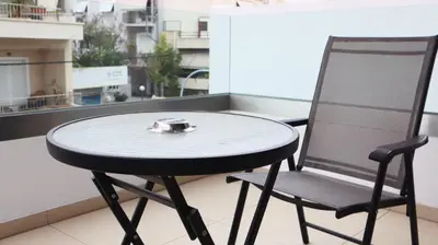 a table and a chair on a balcony at Dafni City Apartment 3 in Athens