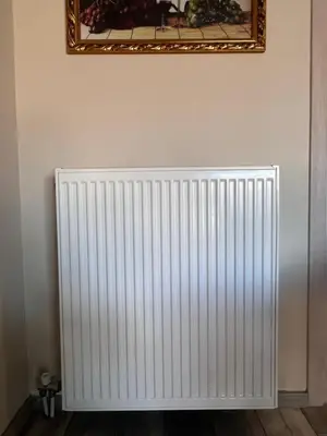 a white radiator against a wall with a mirror at Dafni City Apartment 3 in Athens