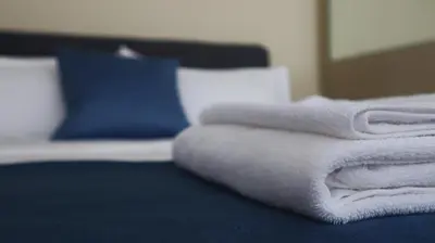 a pile of towels sitting on top of a bed at Dafni City Apartment 3 in Athens