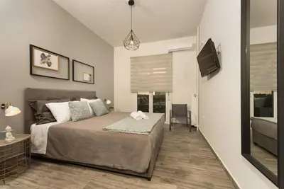 a bedroom with a bed and a flat screen tv at Our Cosy home - AT001 in Athens