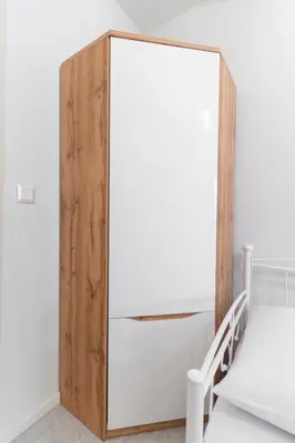 a wooden cabinet next to a bed in a room at Aiolos kolonaki near Hilton super lux apartment in Athens