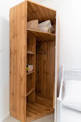 a wooden cupboard in the corner of a bedroom at Aiolos kolonaki near Hilton super lux apartment in Athens