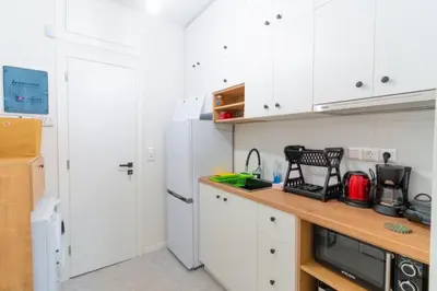 a kitchen with white cabinets and a white refrigerator at Aiolos kolonaki near Hilton super lux apartment in Athens