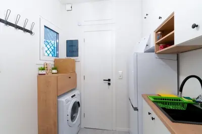 a laundry room with a washer and dryer in a kitchen at Aiolos kolonaki near Hilton super lux apartment in Athens