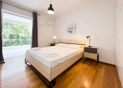 a bedroom with a large bed and a large window at Metamorfoseos Spacious 120sqm apt in Alimos in Athens
