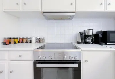 a kitchen with white cabinets and a stove top oven at Metamorfoseos Spacious 120sqm apt in Alimos in Athens