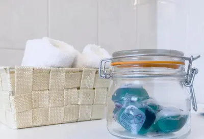 a mason jar with toothpaste and a basket of towels at Metamorfoseos Spacious 120sqm apt in Alimos in Athens