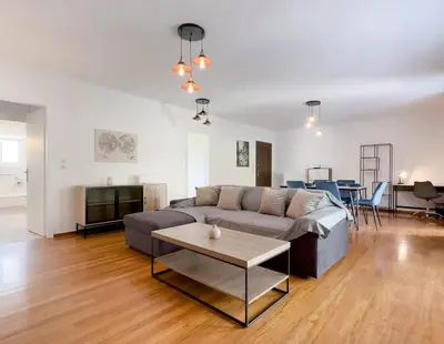 a living room with a couch and a table at Metamorfoseos Spacious 120sqm apt in Alimos in Athens