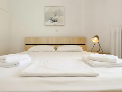 a white bed with two white towels on it at Metamorfoseos Spacious 120sqm apt in Alimos in Athens