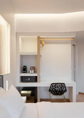 a bedroom with a bed and a desk with a chair at Kreoli Hotel in Athens
