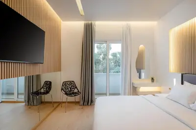 a hotel room with a bed and a tv at Kreoli Hotel in Athens