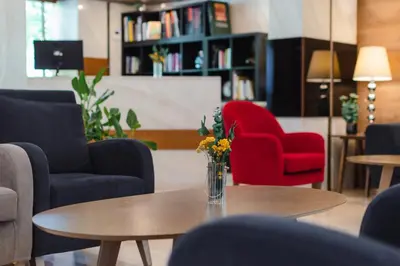 a living room with chairs and a table with flowers on it at Acropol Hotel in Athens