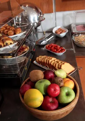 a bowl of fruit on a counter with other foods at Acropol Hotel in Athens