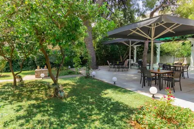 a patio with tables and chairs under a large umbrella at Acropol Hotel in Athens