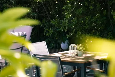 a wooden table and chairs in a garden at Acropol Hotel in Athens
