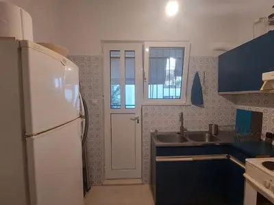 a kitchen with a white refrigerator and a sink at quiet apartment with a large balcony near the sea in Athens