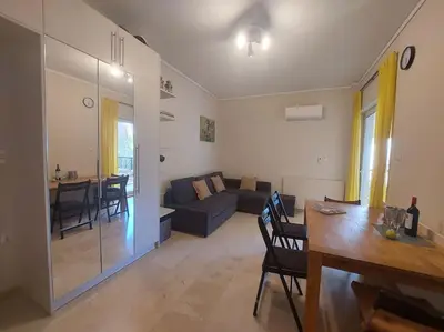 a living room with a couch and a table at quiet apartment with a large balcony near the sea in Athens