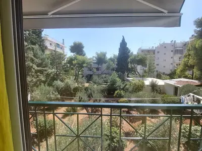 a view of a garden from a window at quiet apartment with a large balcony near the sea in Athens
